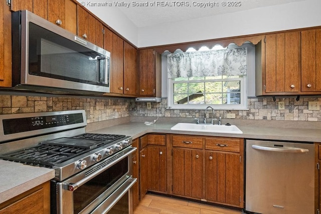 169 Burning Springs Dr, Belle, WV 25015 - kitchen featuring stainless steel appliances, a sink, decorative backsplash, brown cabinets, and a textured ceiling
