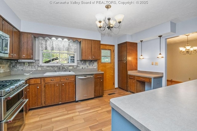 169 Burning Springs Dr, Belle, WV 25015 - kitchen with appliances with stainless steel finishes, a chandelier, a sink, tasteful backsplash, and light wood-style flooring