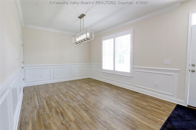 4210 Fairway Xing, South Charleston, WV 25309 - unfurnished dining area featuring a chandelier, ornamental molding, plenty of natural light, light wood-type flooring, and a decorative wall