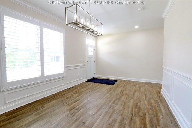 4210 Fairway Xing, South Charleston, WV 25309 - unfurnished dining area with ornamental molding, wood finished floors, a wainscoted wall, a decorative wall, and a chandelier