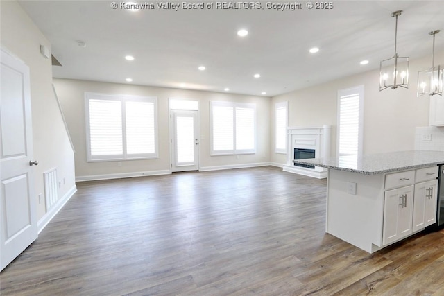 4210 Fairway Xing, South Charleston, WV 25309 - kitchen with a chandelier, white cabinets, a glass covered fireplace, open floor plan, and wood finished floors