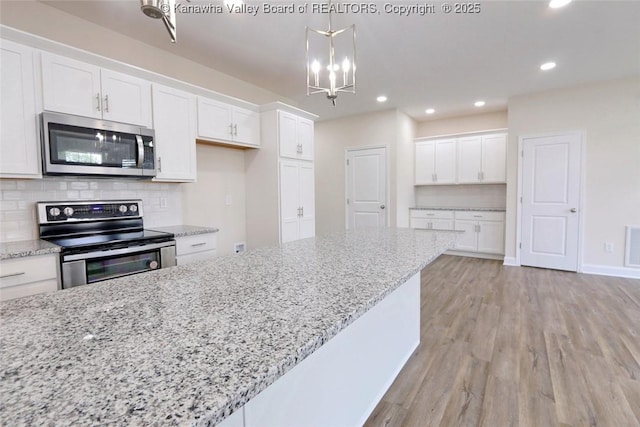 4210 Fairway Xing, South Charleston, WV 25309 - kitchen featuring stainless steel appliances, white cabinetry, light wood-type flooring, recessed lighting, and a chandelier