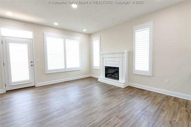 4210 Fairway Xing, South Charleston, WV 25309 - unfurnished living room featuring wood finished floors, a glass covered fireplace, baseboards, and recessed lighting