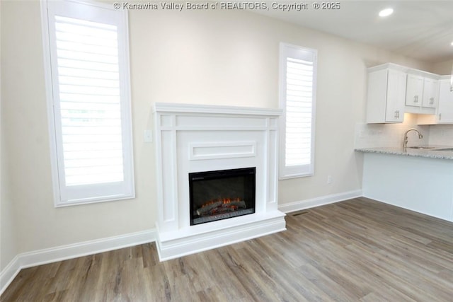 4210 Fairway Xing, South Charleston, WV 25309 - unfurnished living room featuring wood finished floors, a sink, baseboards, a lit fireplace, and recessed lighting