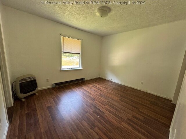 2608 Procious Maysel Rd, Wv, WV 25133 - unfurnished room featuring a baseboard radiator, heating unit, wood finished floors, a textured ceiling, and baseboards