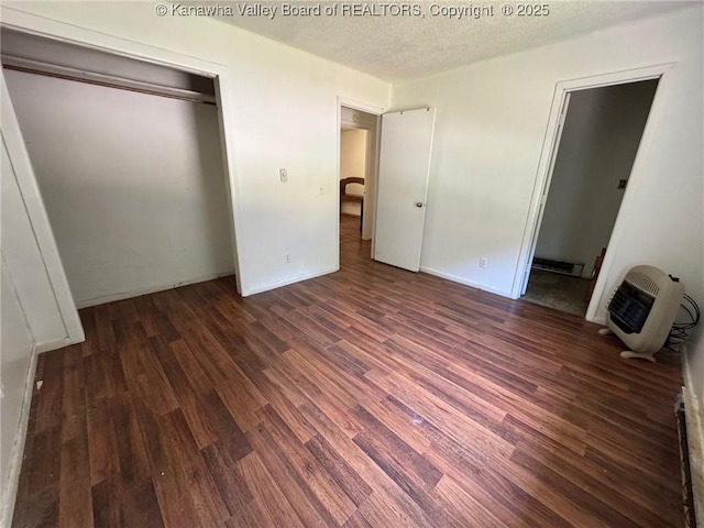 2608 Procious Maysel Rd, Wv, WV 25133 - unfurnished bedroom with heating unit, wood finished floors, a closet, a textured ceiling, and baseboards