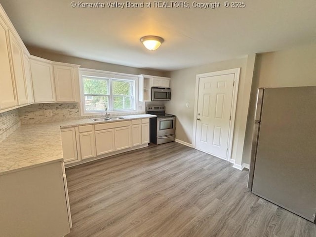 547 Garrison Ave, Charleston, WV 25302 - kitchen featuring stainless steel appliances, light wood finished floors, light countertops, backsplash, and a sink