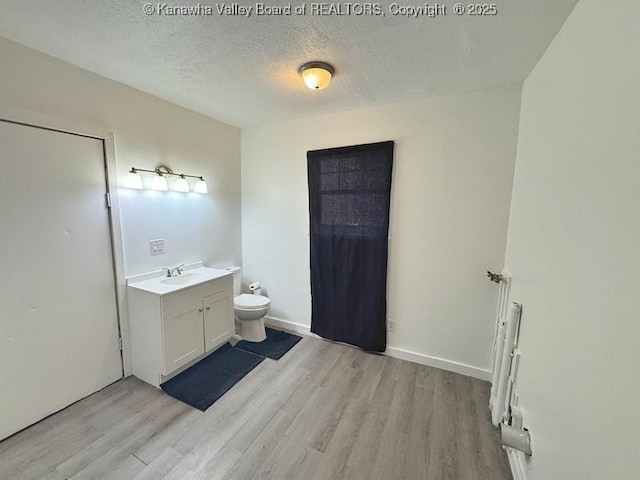 547 Garrison Ave, Charleston, WV 25302 - full bath with vanity, wood finished floors, toilet, a textured ceiling, and baseboards