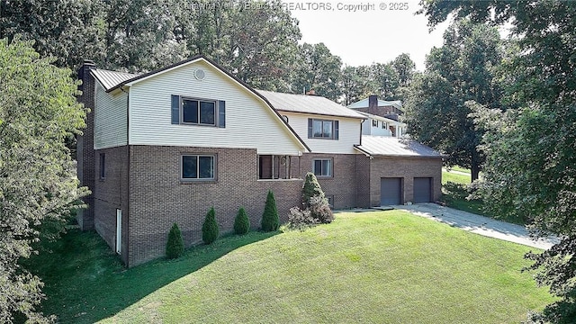 124 Morningside Dr, Elkview, WV 25071 - view of front of home with a front yard, driveway, a garage, brick siding, and view of wooded area