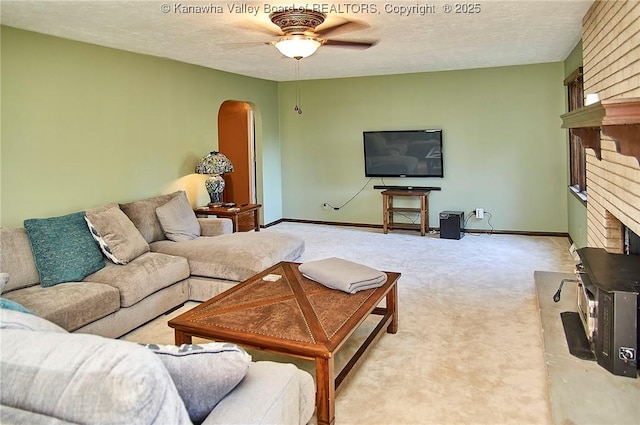 124 Morningside Dr, Elkview, WV 25071 - carpeted living room featuring a fireplace, arched walkways, ceiling fan, and a textured ceiling