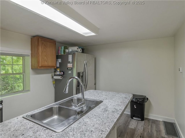 3742 Greenview Rd, South Charleston, WV 25309 - kitchen with stainless steel fridge, dark wood-style flooring, brown cabinetry, light countertops, and a peninsula