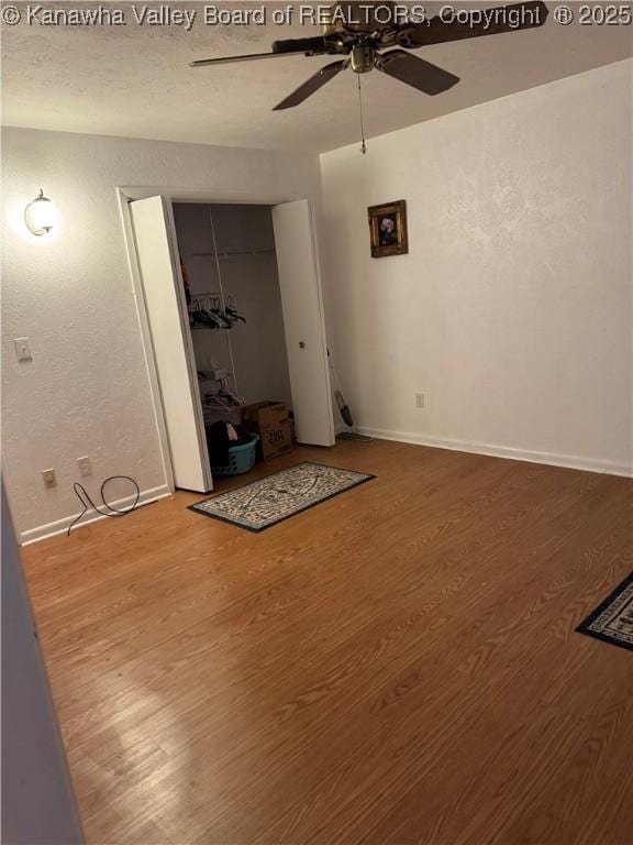 194 Shawnee Ests, Winfield, WV 25213 - unfurnished living room featuring ceiling fan, wood finished floors, and a textured wall