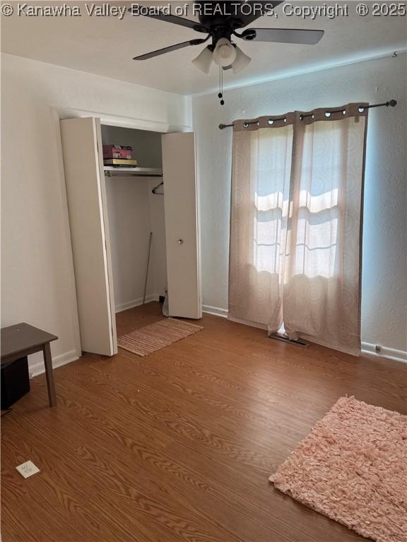 194 Shawnee Ests, Winfield, WV 25213 - unfurnished bedroom featuring wood finished floors, a closet, and a ceiling fan