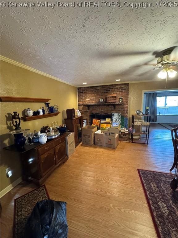 194 Shawnee Ests, Winfield, WV 25213 - living area featuring a textured ceiling, a brick fireplace, wood finished floors, a ceiling fan, and crown molding