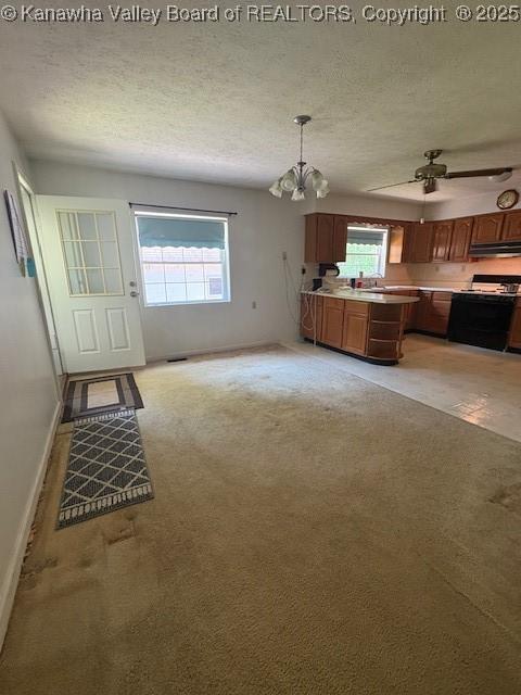 3202 Wallback Rd, Wallback, WV 25285 - unfurnished living room with a chandelier, healthy amount of natural light, light colored carpet, a textured ceiling, and a ceiling fan