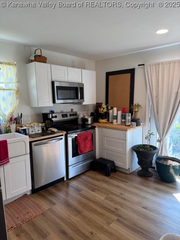 1003 Ridge Dr, South Charleston, WV 25309 - kitchen with stainless steel appliances, white cabinets, wood finished floors, and recessed lighting
