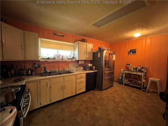 912 Ann St, Ravenswood, WV 26164 - kitchen featuring stainless steel appliances, a textured ceiling, light countertops, white cabinetry, and wood walls