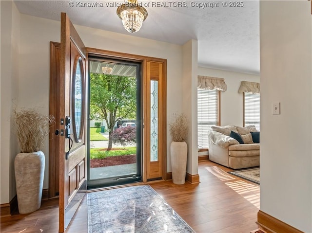 53 Wildrose Ln, Scott Depot, WV 25560 - entrance foyer featuring wood finished floors, a chandelier, and a textured ceiling