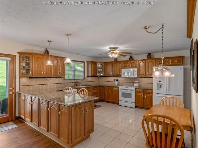 53 Wildrose Ln, Scott Depot, WV 25560 - kitchen with white appliances, brown cabinetry, a peninsula, and glass insert cabinets