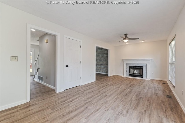 1571 Thistlewood Cir, Hurricane, WV 25526 - unfurnished living room featuring a ceiling fan, light wood finished floors, a premium fireplace, and stairs