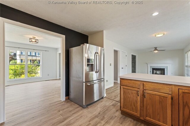 1571 Thistlewood Cir, Hurricane, WV 25526 - kitchen with stainless steel fridge with ice dispenser, open floor plan, ceiling fan, light wood-style floors, and brown cabinetry
