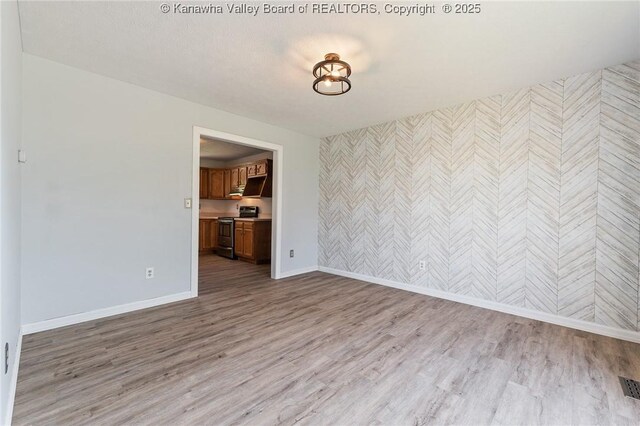 1571 Thistlewood Cir, Hurricane, WV 25526 - empty room with wallpapered walls, light wood-style floors, and an accent wall