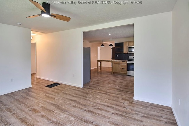 911 Dupont Ave, Nitro, WV 25143 - unfurnished living room with wood finished floors, a ceiling fan, and a textured ceiling