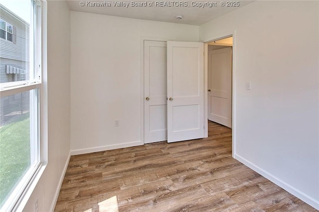 911 Dupont Ave, Nitro, WV 25143 - unfurnished bedroom featuring wood finished floors and baseboards