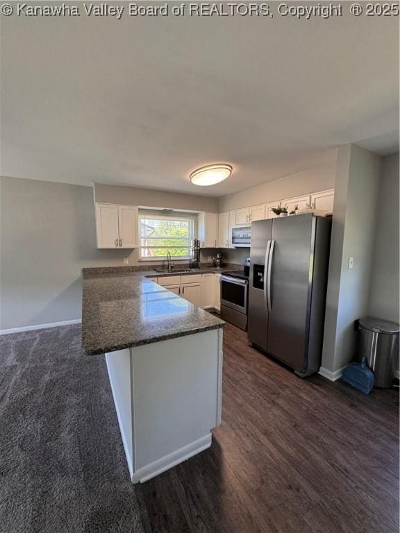 3007 Sansom Ct, Milton, WV 25541 - kitchen featuring appliances with stainless steel finishes, a peninsula, white cabinets, dark wood-style flooring, and dark stone countertops