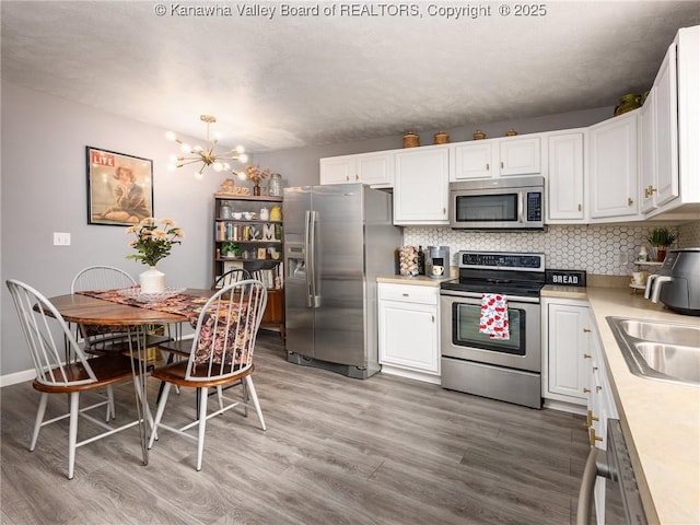 732 Jordan Pl, Nitro, WV 25143 - kitchen with appliances with stainless steel finishes, light wood finished floors, light countertops, and white cabinetry