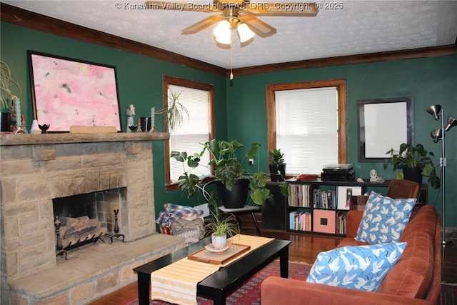 1840-A Oakridge Dr, Charleston, WV 25311 - living room featuring ceiling fan, wood finished floors, a stone fireplace, a textured ceiling, and ornamental molding