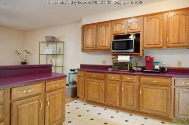 690 Rambling Hills Rd, Elkview, WV 25071 - kitchen with stainless steel microwave, dark countertops, light floors, and brown cabinets