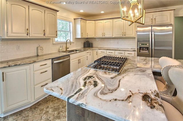 1004 Wethersfield Xing, Hurricane, WV 25526 - kitchen with appliances with stainless steel finishes, a kitchen breakfast bar, light stone countertops, backsplash, and a chandelier