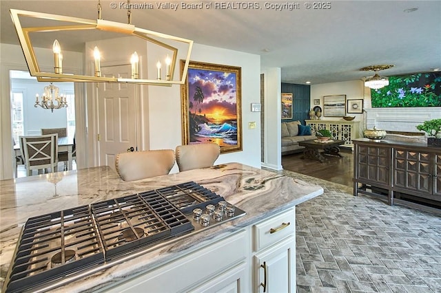 1004 Wethersfield Xing, Hurricane, WV 25526 - kitchen featuring a chandelier, stainless steel gas cooktop, white cabinetry, light stone counters, and open floor plan