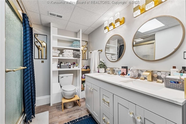 916 Amherst Dr, Charleston, WV 25302 - bathroom featuring a paneled ceiling, wood finished floors, double vanity, and a shower with door