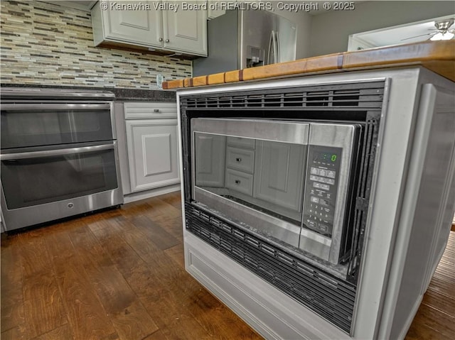 227 Maplewood Ests, Scott Depot, WV 25560 - kitchen view of appliances with stainless steel finishes, dark wood-type flooring, white cabinets, backsplash, and dark countertops