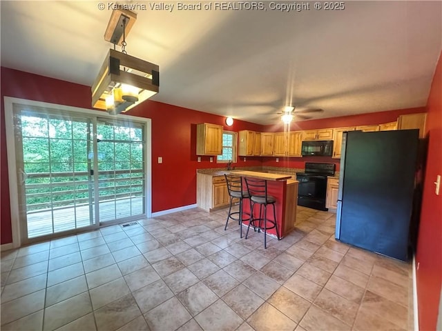 4136 Iva Durst Rd, Leon, WV 25123 - kitchen featuring black appliances, a center island, a breakfast bar area, light countertops, and a ceiling fan