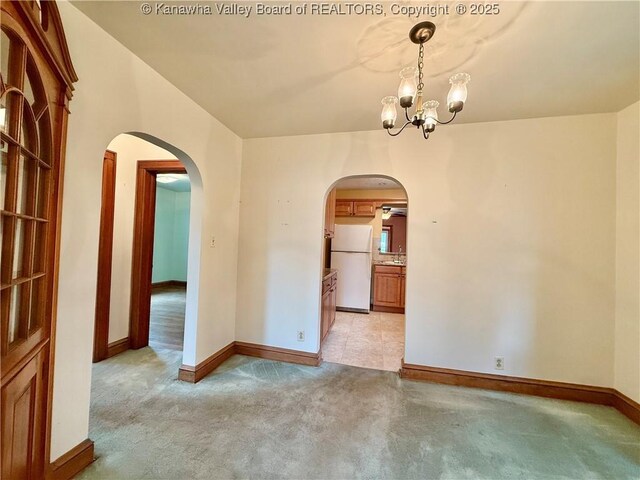 108 W Main St, Belle, WV 25015 - unfurnished room featuring arched walkways, a chandelier, and light carpet