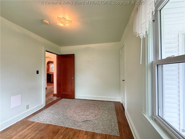 108 W Main St, Belle, WV 25015 - empty room featuring wood finished floors, arched walkways, healthy amount of natural light, and a smoke detector