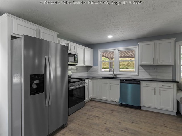 5285 Kelly Rd, Charleston, WV 25313 - kitchen featuring stainless steel appliances, dark countertops, a textured ceiling, backsplash, and dark wood-style floors