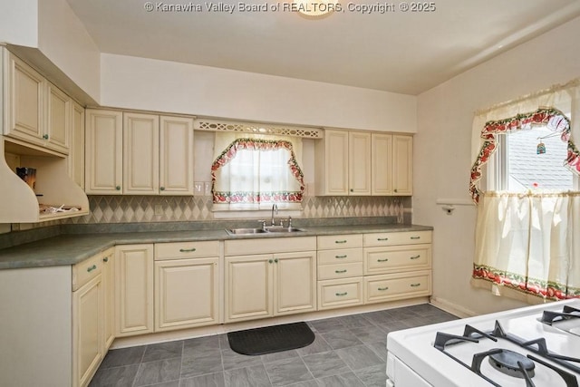 104 E Riverview Dr, Belle, WV 25015 - kitchen featuring cream cabinetry, white range with gas stovetop, and decorative backsplash