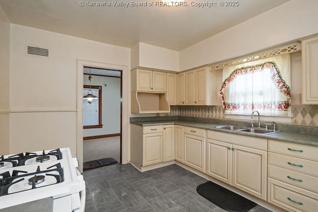 104 E Riverview Dr, Belle, WV 25015 - kitchen featuring cream cabinets, decorative backsplash, white range with gas stovetop, and dark countertops