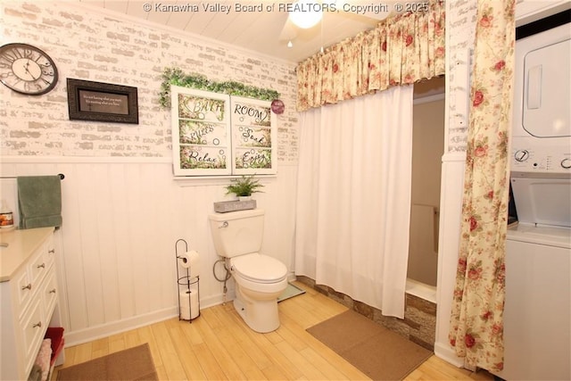 960 Grandview Rd, Daniels, WV 25832 - bathroom featuring stacked washer / dryer, wood finished floors, wallpapered walls, a wainscoted wall, and vanity
