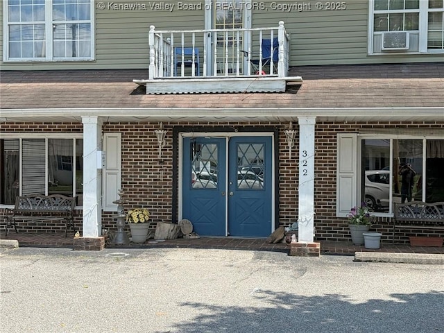 322 16th St, Dunbar, WV 25064 - view of exterior entry with brick siding, a balcony, and covered porch