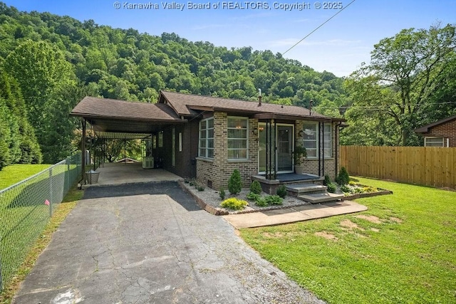 9627 Procious Maysel Rd, Procious, WV 25164 - view of front of home featuring driveway, a carport, brick siding, and a wooded view