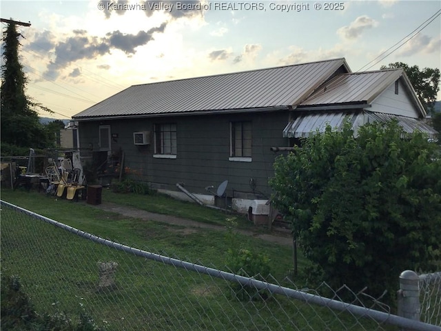 4428 Pennsylvania Ave, South Charleston, WV 25309 - back of house at dusk with a fenced backyard, a metal roof, and a wall mounted air conditioner