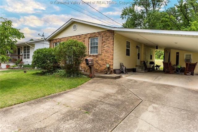 3983 39th St E, Nitro, WV 25143 - view of home's exterior with concrete driveway, a carport, a lawn, and brick siding