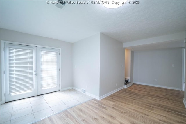 2023 Roxalana Rd, Dunbar, WV 25064 - empty room with wood finished floors, french doors, and a textured ceiling