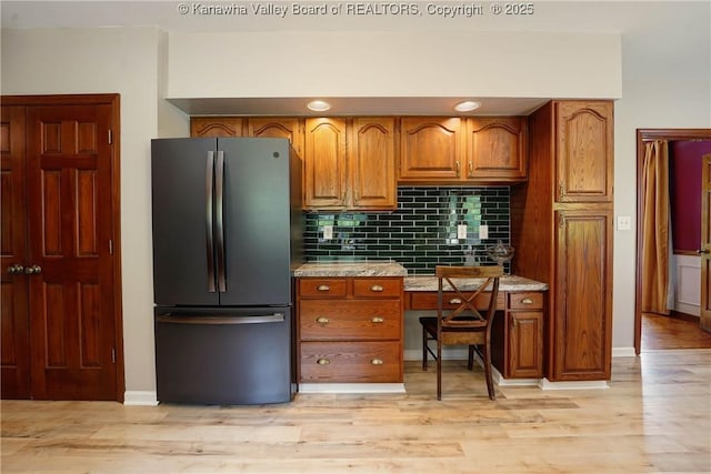 32 Carriage Rd, Charleston, WV 25314 - kitchen featuring freestanding refrigerator, brown cabinets, and tasteful backsplash