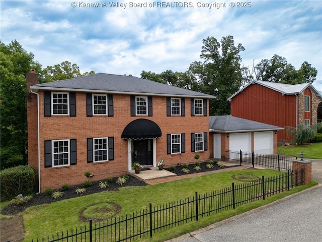 81 Hamill Rd, Huntington, WV 25701 - colonial house with a chimney, concrete driveway, brick siding, and a garage